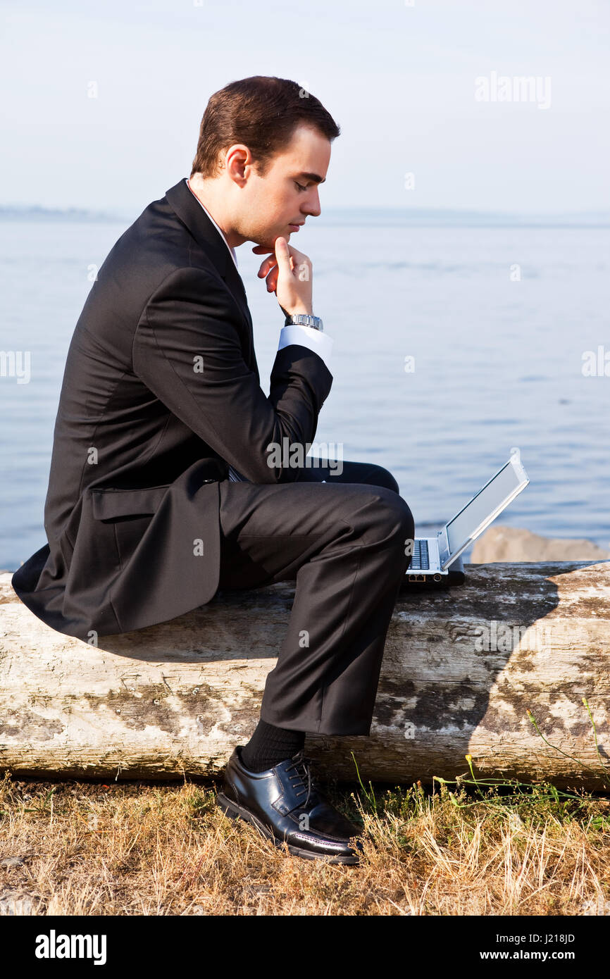 A caucasian businessman working on his laptop outdoor Stock Photo - Alamy