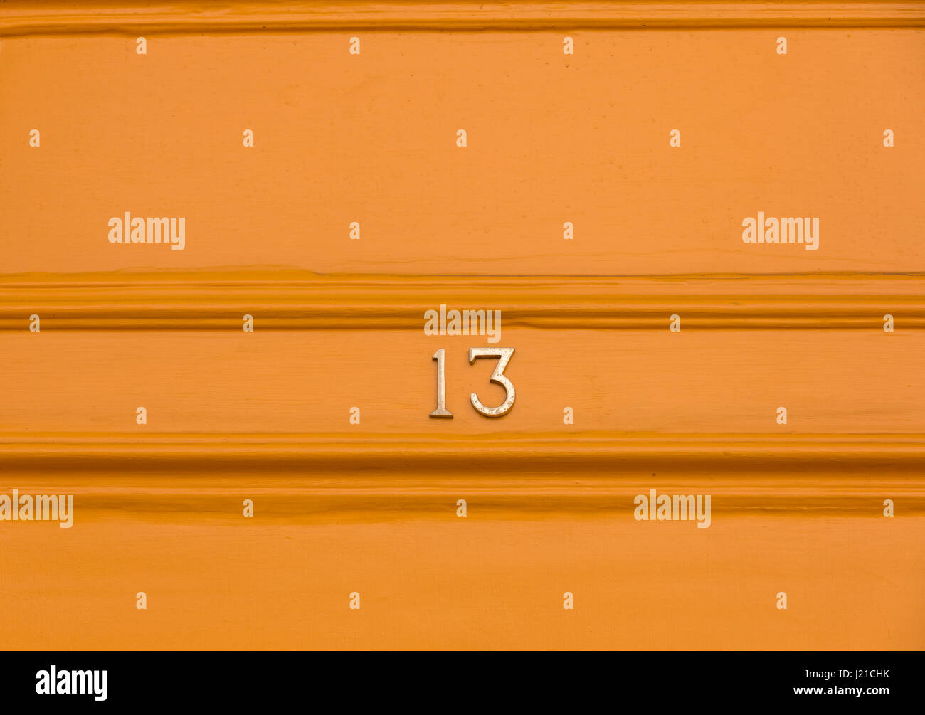 the number 13 in brass numbers on an orange background, Bath, England, UK Stock Photo