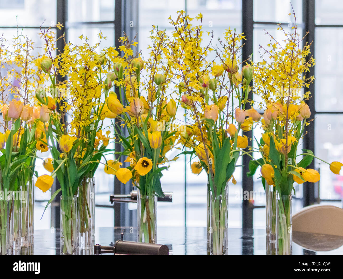 gorgeous yellow flowers in glass vases in a London Hotel lobby Stock Photo