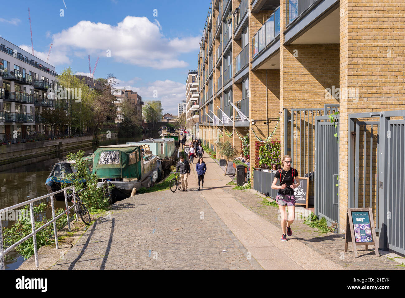 People walking along a stretch of the Regent's Canal in Haggerston, Hackney, East London. Known as the Haggerston Riviera and lined with cafes and art Stock Photo