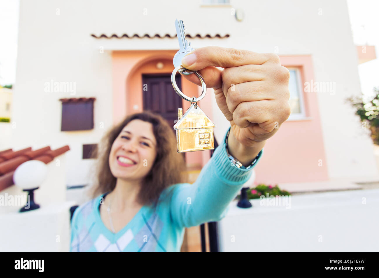 Happy young woman In Front of New Home with New House Keys Stock Photo ...