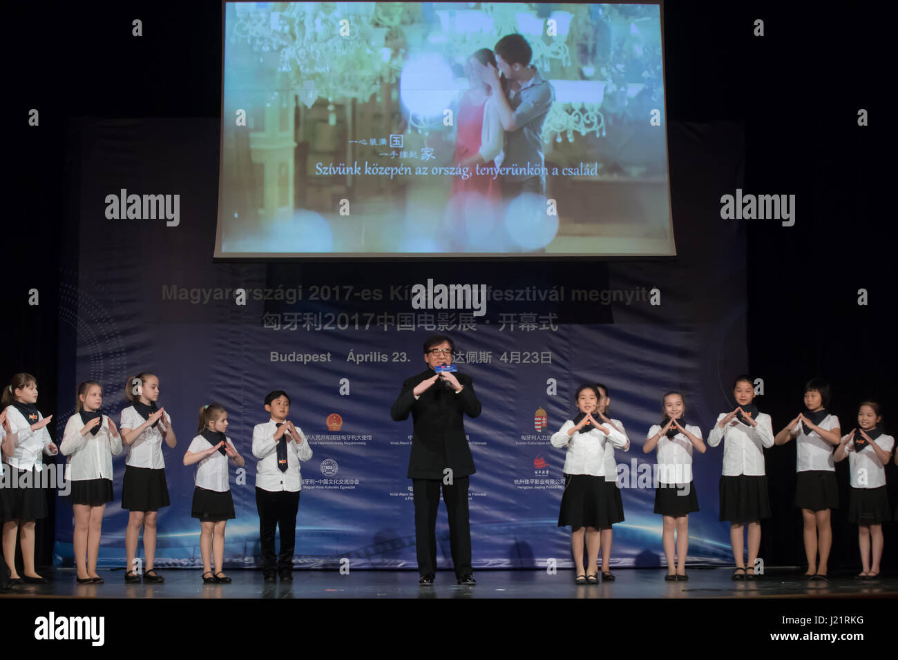 Budapest, Hungary. 23rd Apr, 2017. Movie star Jackie Chan (C) sings during the opening ceremony of the 2017 Chinese Film Festival at the Urania National Film Theater in Budapest, Hungary, on April 23, 2017. The 2017 Chinese Film Festival started here on Sunday with the presence of world famous film star Jackie Chan and five movies, one of which is Jackie Chan's latest production "Kung Fu Yoga". Credit: Attila Volgyi/Xinhua/Alamy Live News Stock Photo