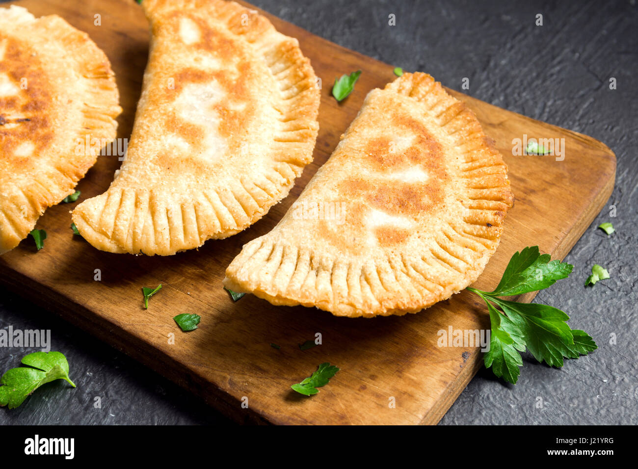 Homemade deep fried vegetable samosas (patties, burekas) on rustic black background - vegetarian fried pastries for snack Stock Photo