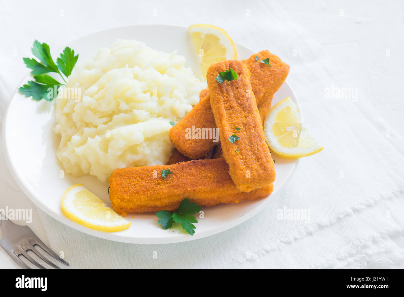Fried fish fingers, mashed potatoes and lemon. Delicious lunch with