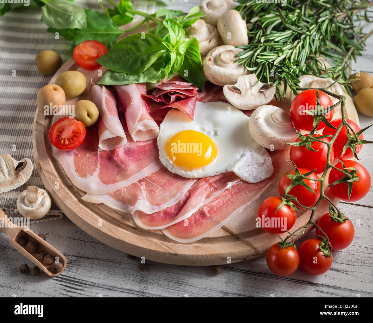 Healthy Mediterranean breakfast groceries fried eggs, ham, vine