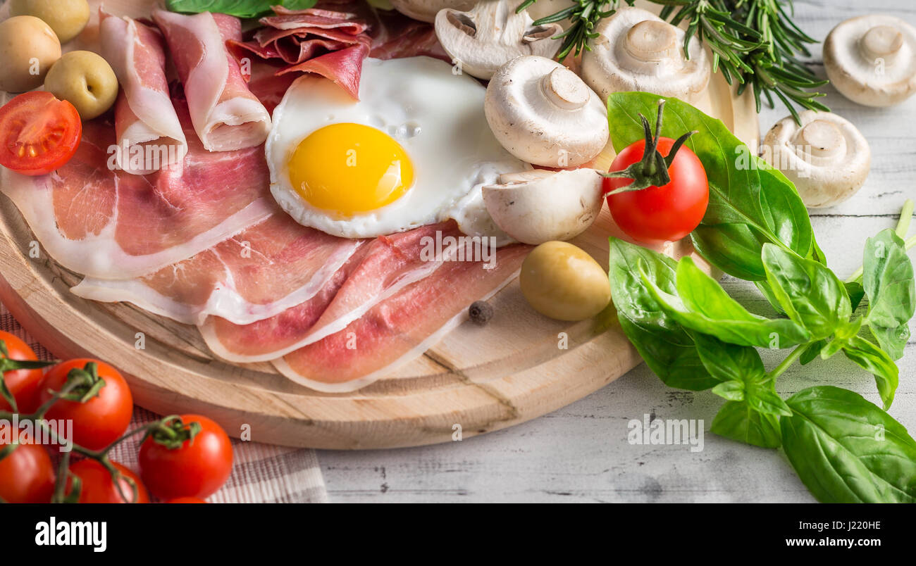 Healthy Mediterranean breakfast groceries fried eggs, ham, vine