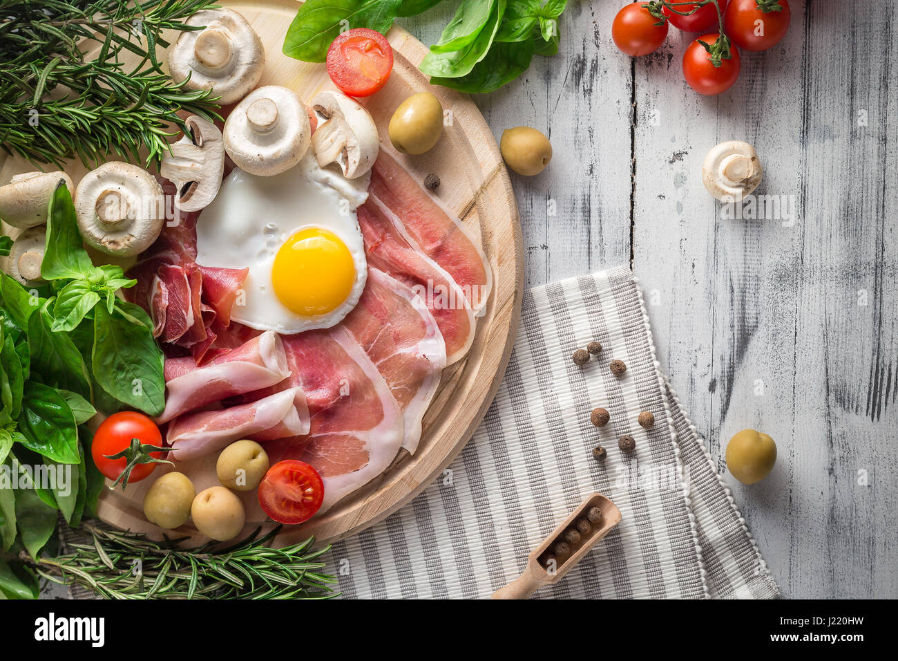 Healthy Mediterranean breakfast groceries fried eggs, ham, vine