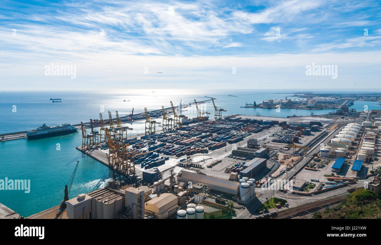 Sunshine on Balearic sea & Barcelona industrial shipping and rail ports on a blue-sky day. Stock Photo