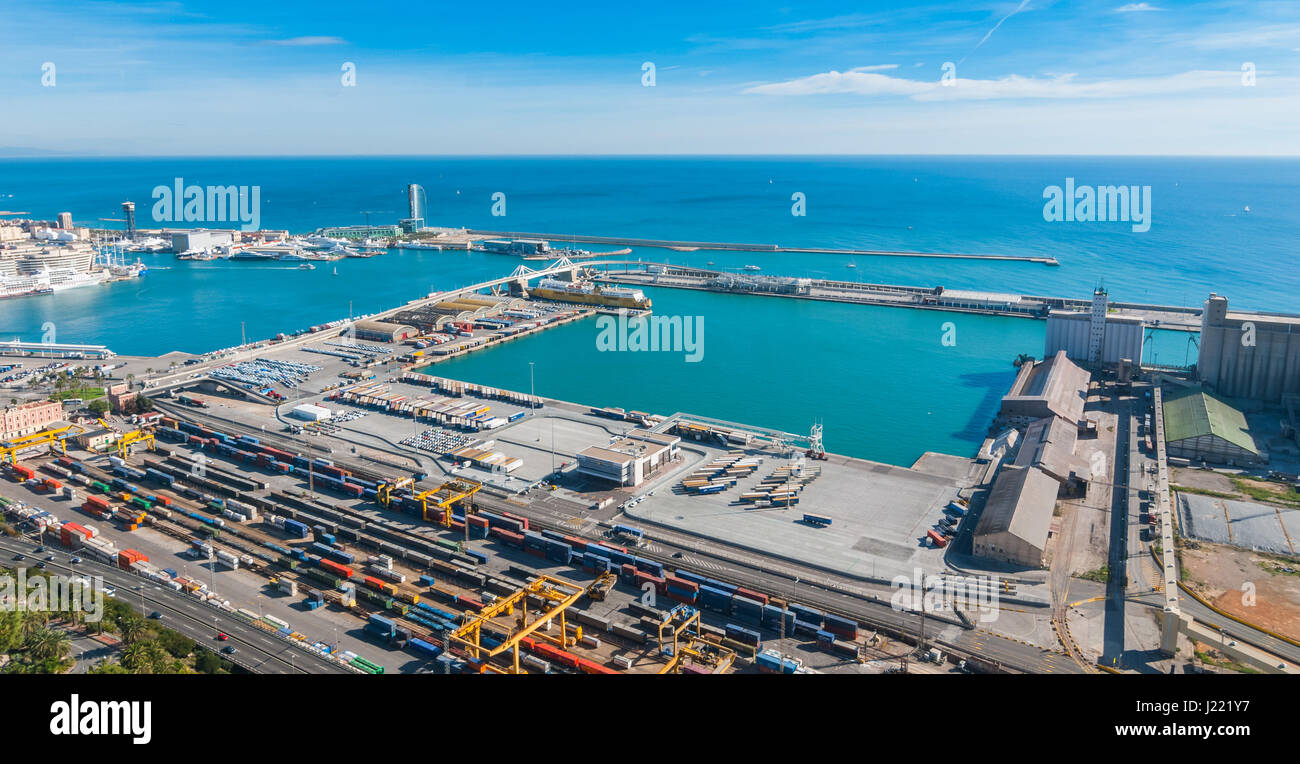 Bright sunny day on the industrial shipping & transport hub & railyard in Barcelona.  Modern cityscape & coastline of Spain. Stock Photo