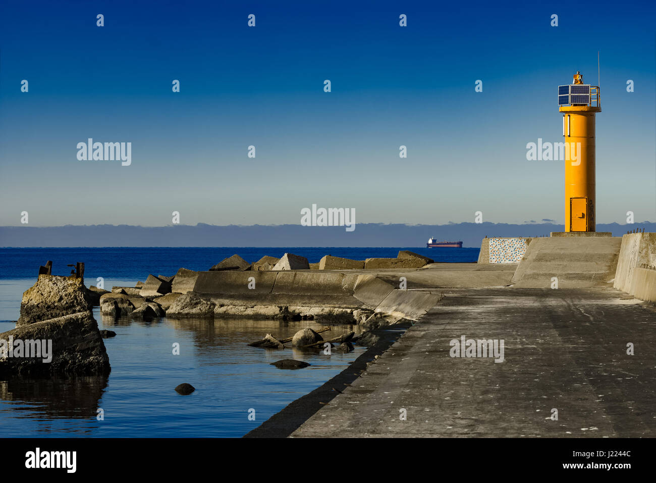 Yellow lighthouse on breakwater dam in Riga, Europe Stock Photo