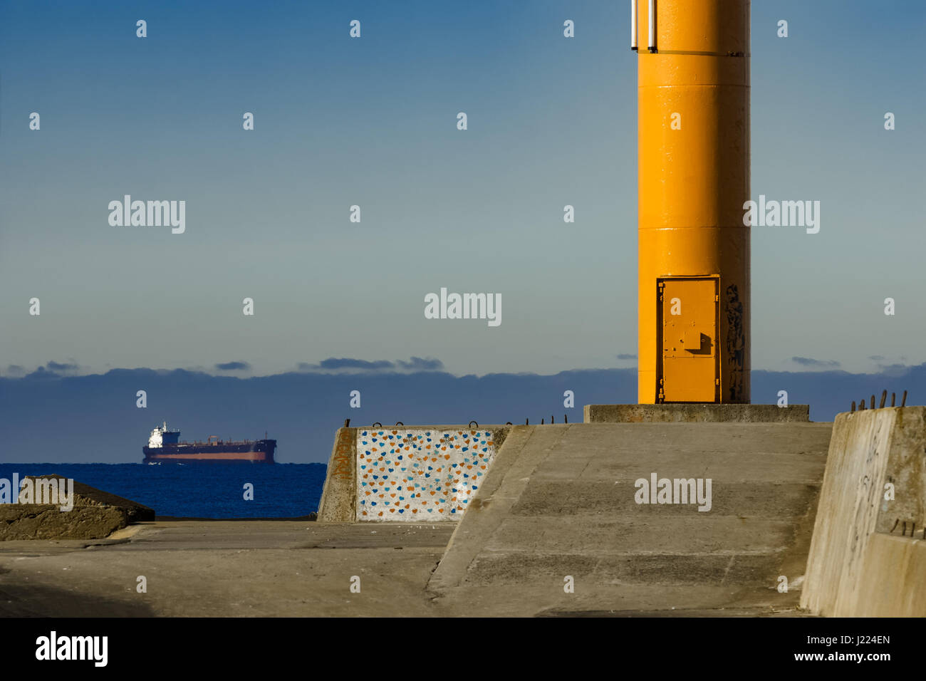 Yellow lighthouse on breakwater dam in Riga, Europe Stock Photo