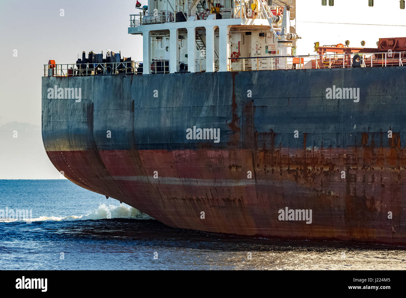 Black cargo ship's stern in still water close up. Riga, Europe Stock