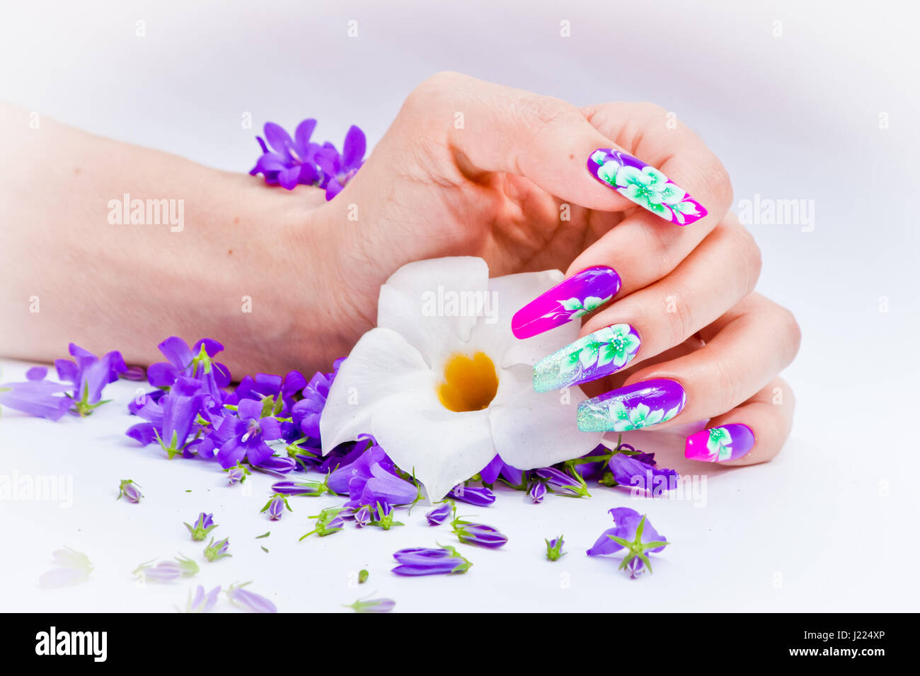 Hand with nails rebuilt and decorated with colorful flowers bring blue and  white floral on white background, beautiful novelty for spring and summer  Stock Photo - Alamy