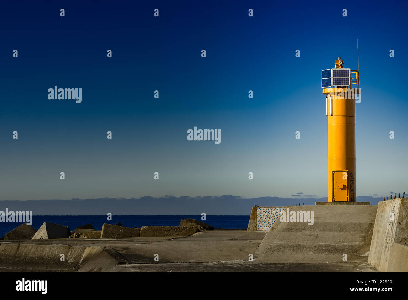 Yellow lighthouse on breakwater dam in Riga, Europe Stock Photo