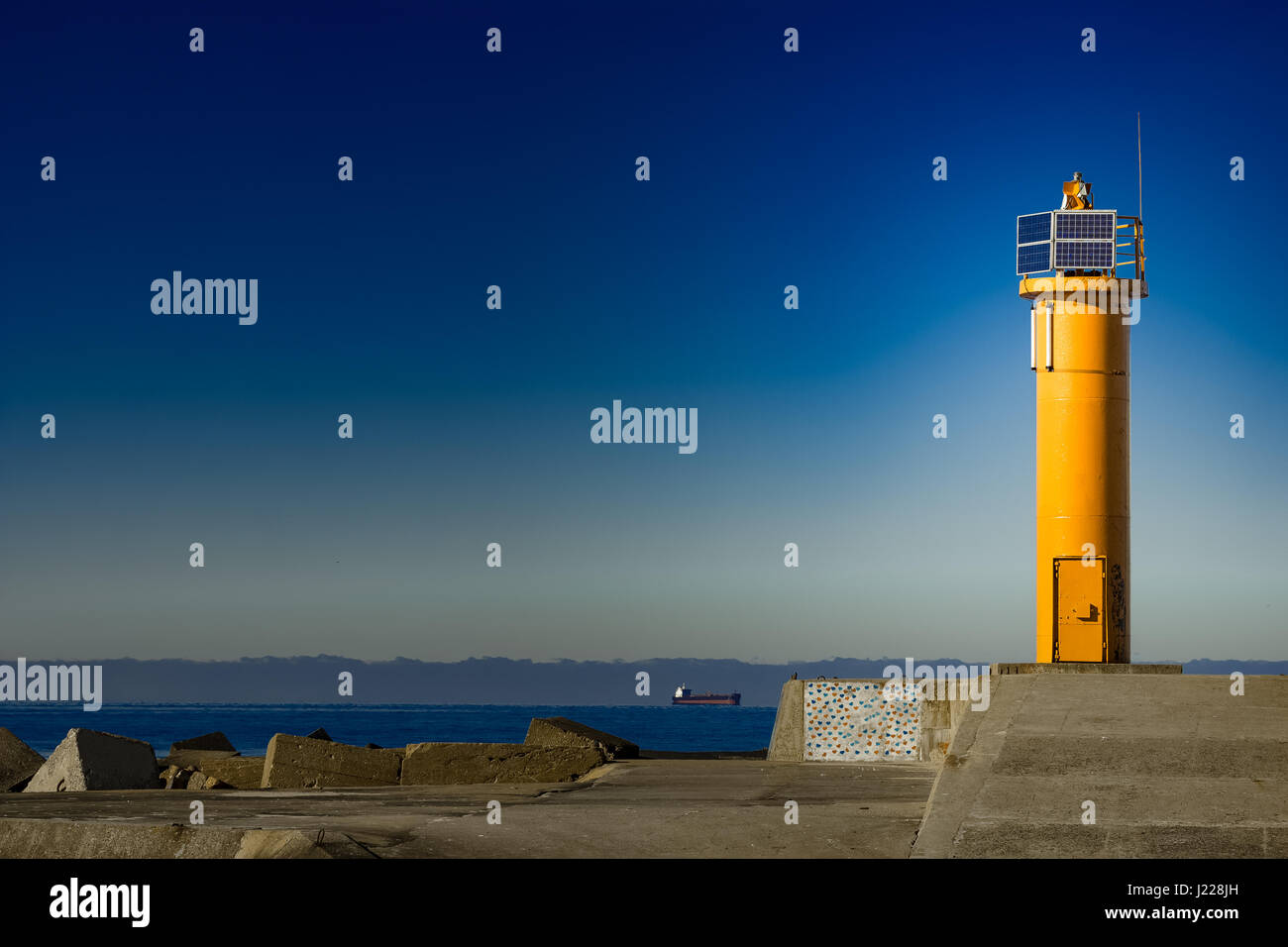 Yellow lighthouse on breakwater dam in Riga, Europe Stock Photo