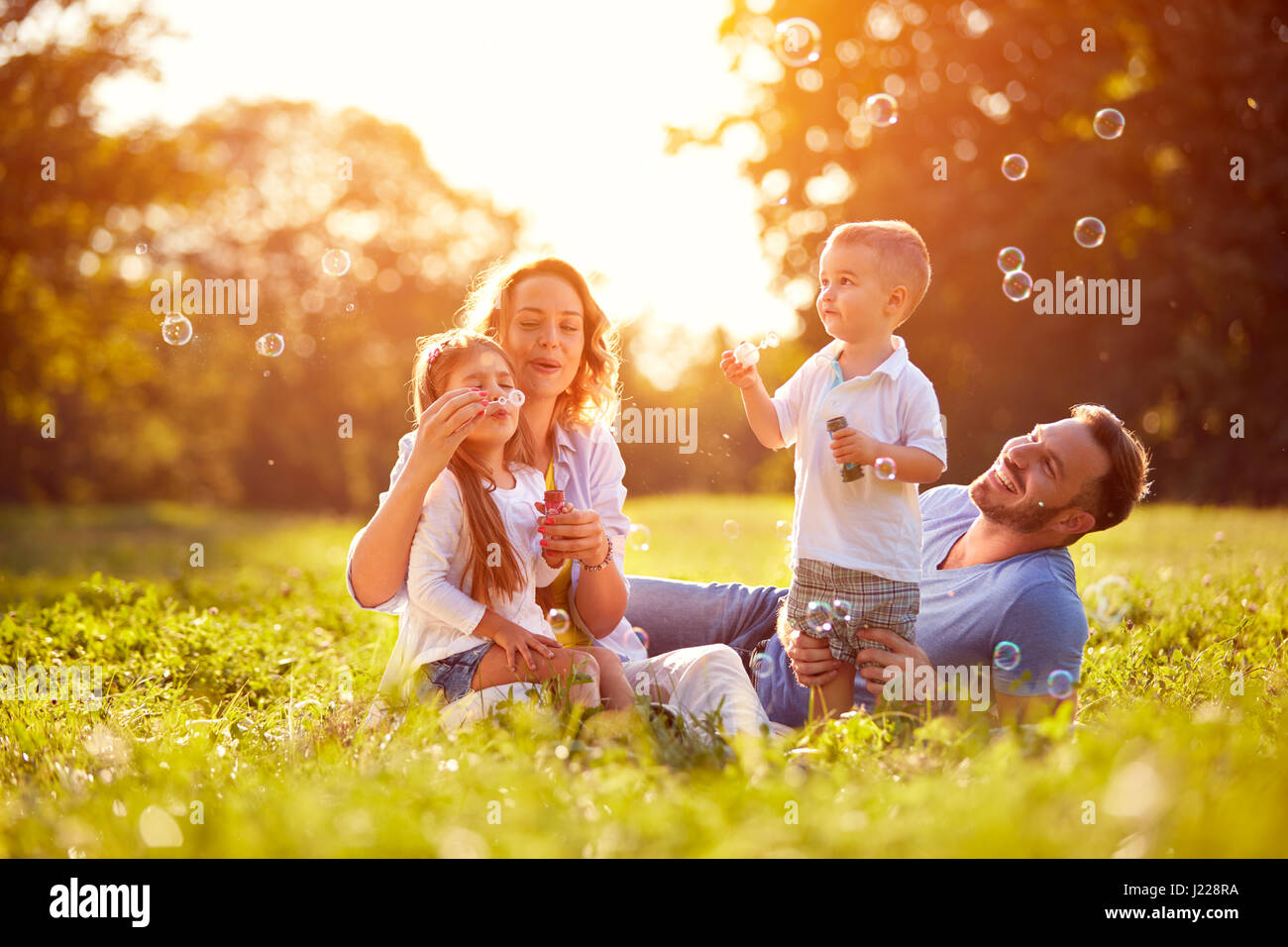 Family with children blow soap bubbles outdoor Stock Photo - Alamy