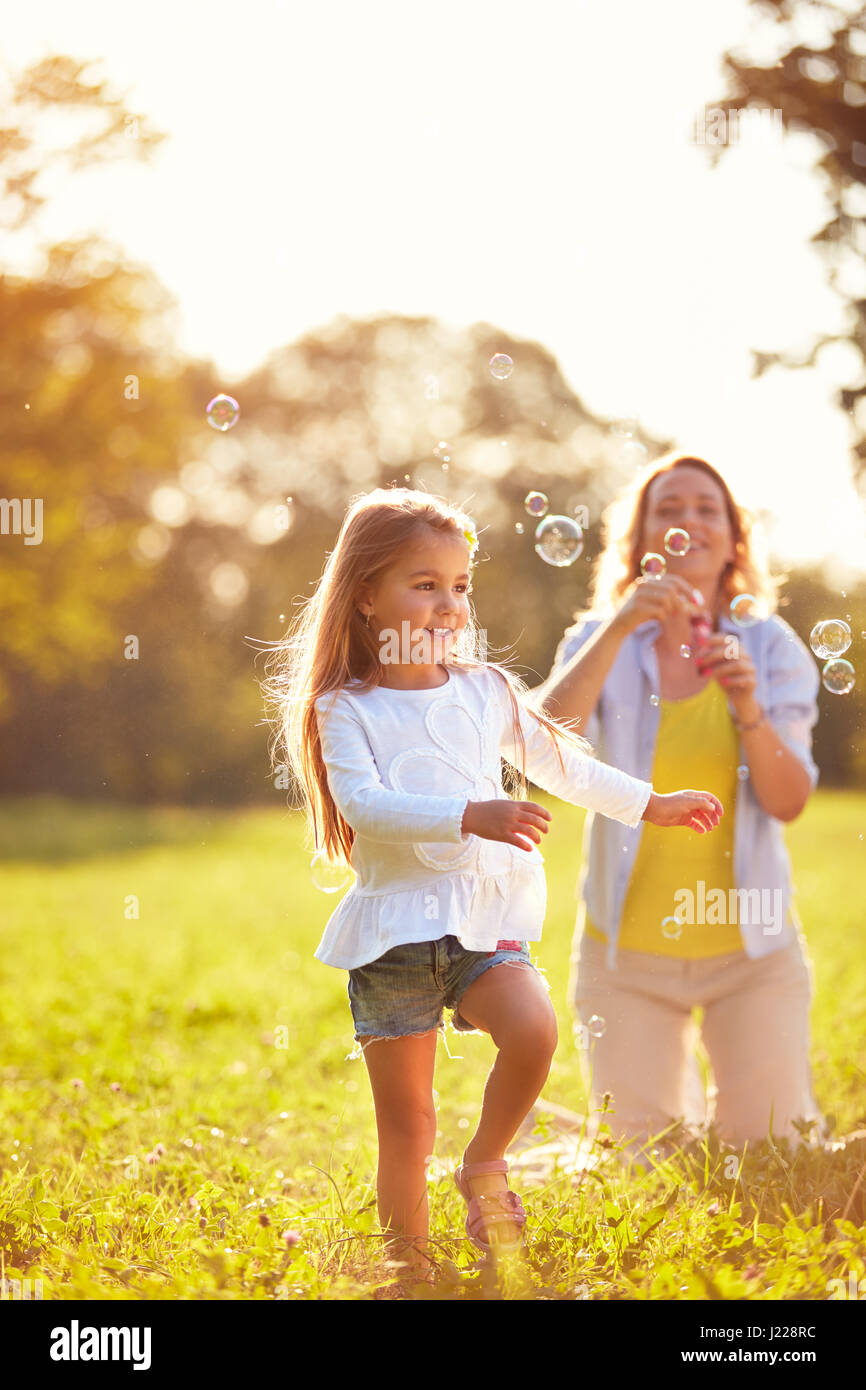 Young child play with soap bubbles in park Stock Photo - Alamy