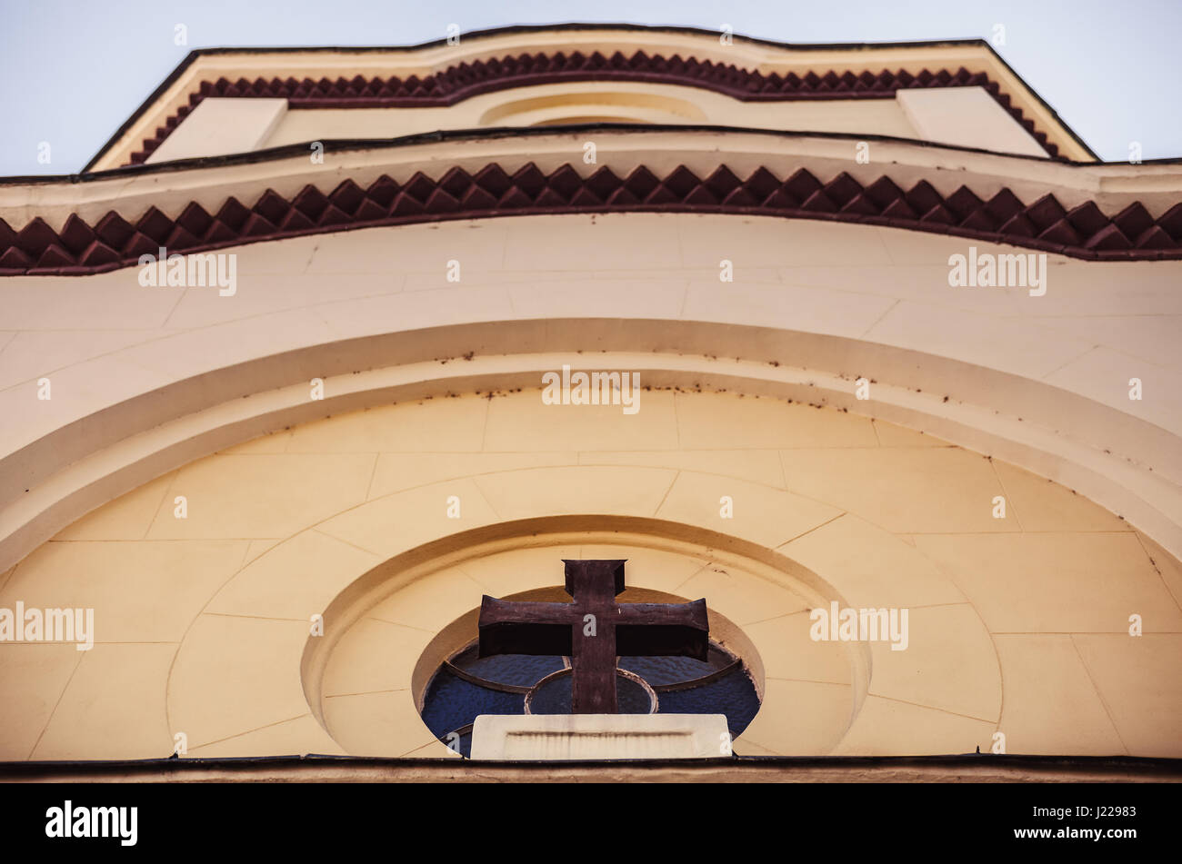 Look above the entrance of a church, wooden cross and wall details. Stock Photo