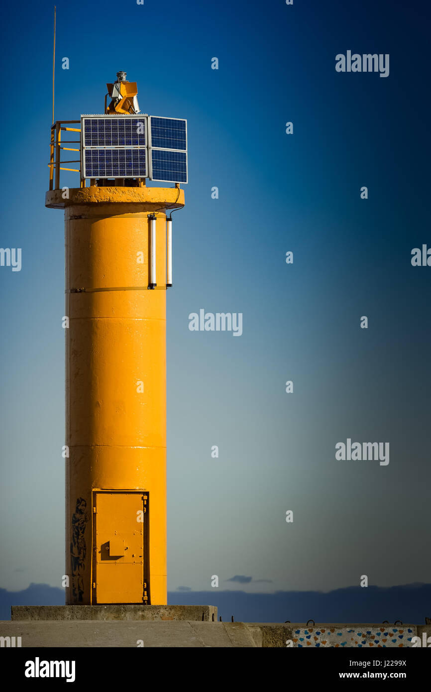 Yellow lighthouse on breakwater dam in Riga, Europe Stock Photo