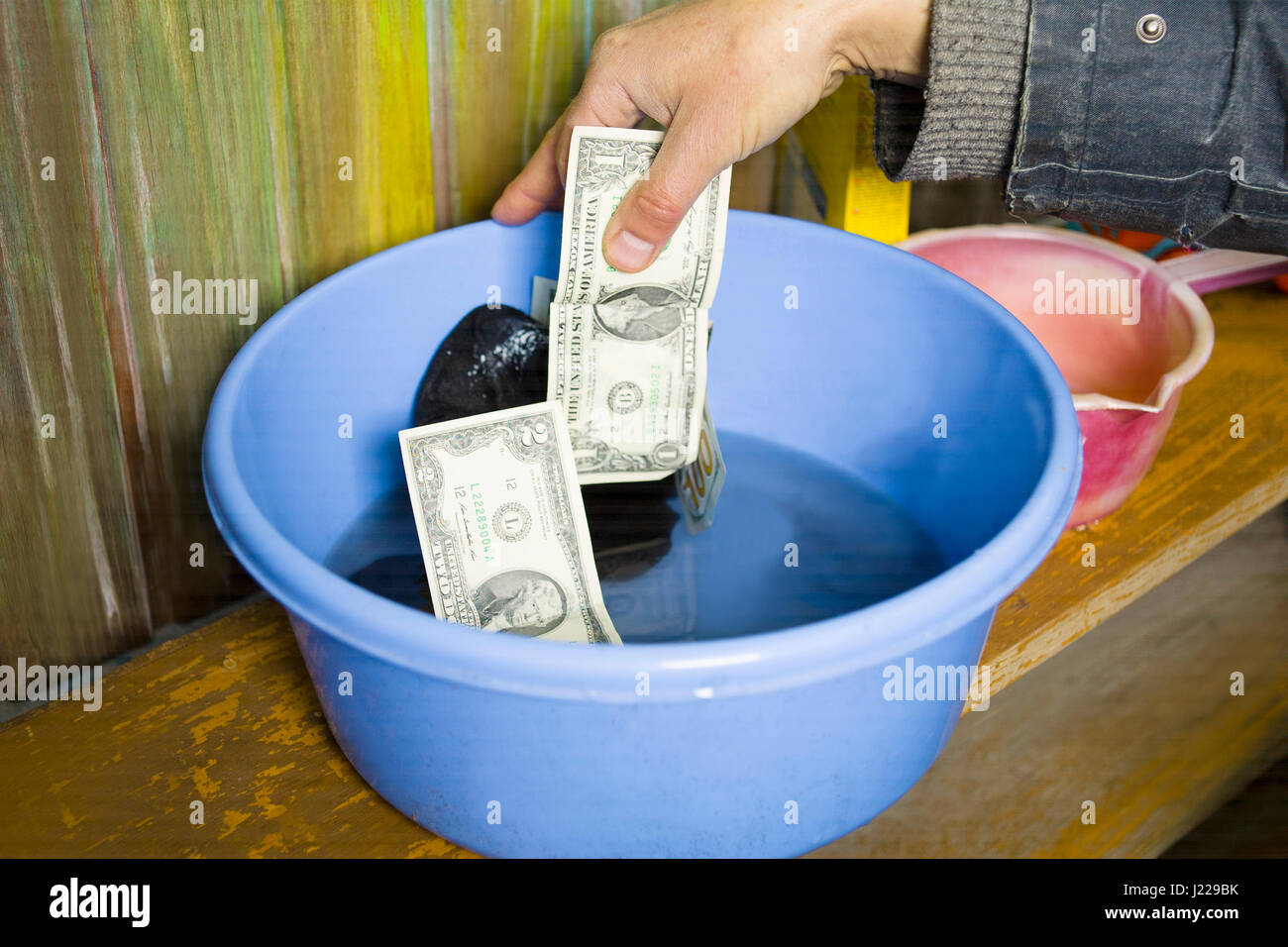 Male hand washing cash and laundry in a blue basin, concept of money laundering Stock Photo Alamy