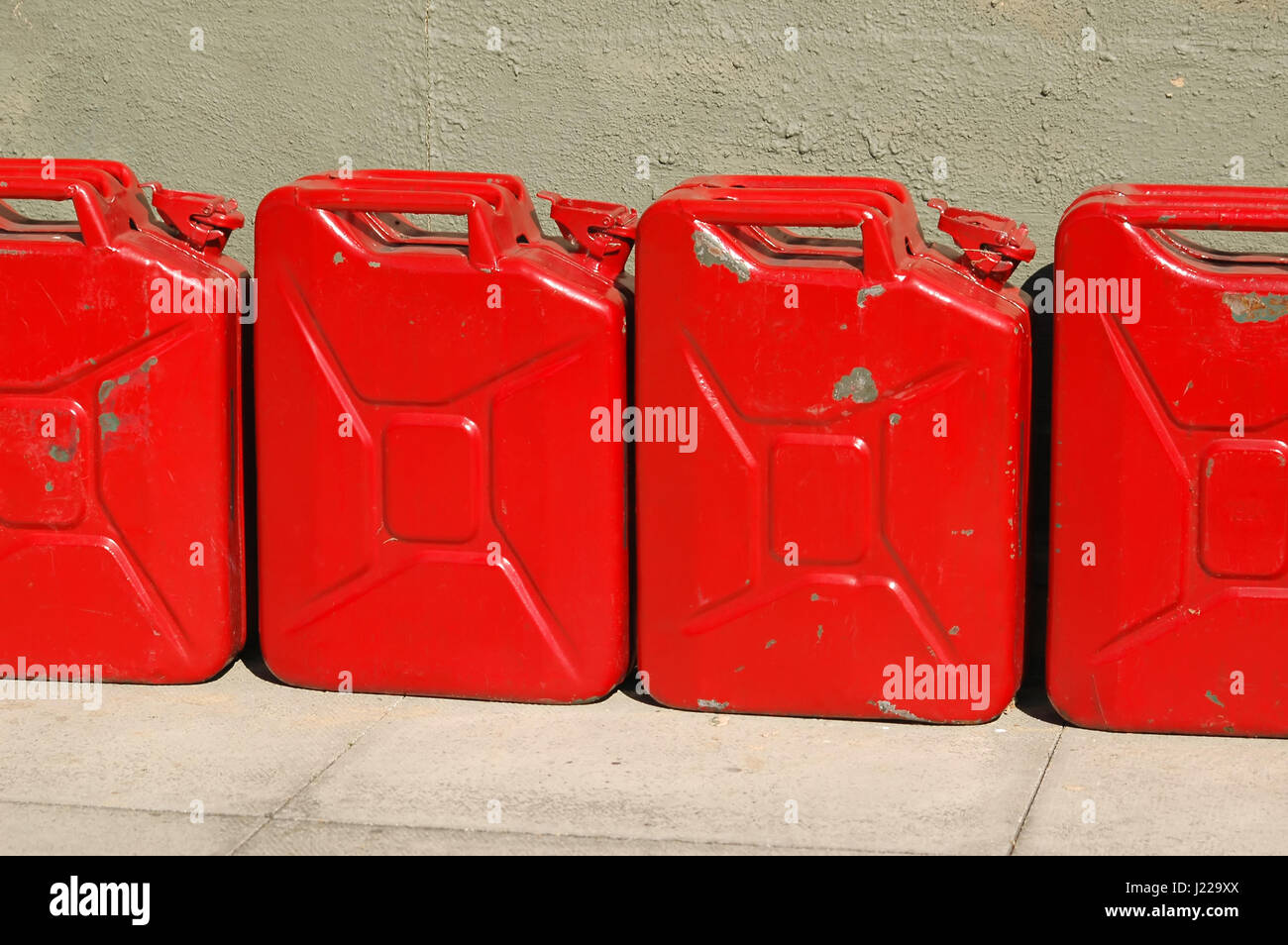 line of battered red gas cans Stock Photo Alamy