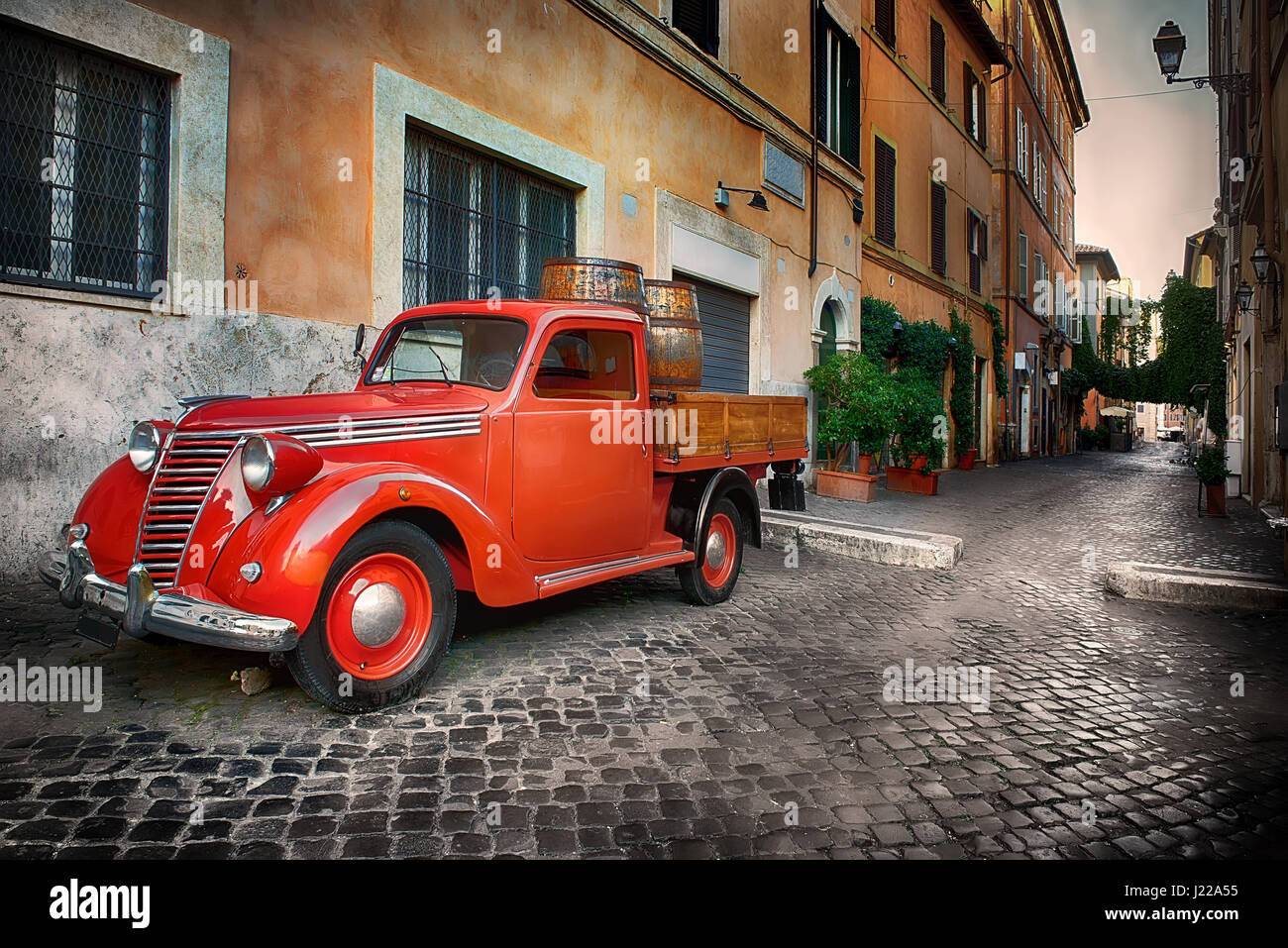 Red retro car on the street of Trastevere in Rome, Italy Stock Photo ...