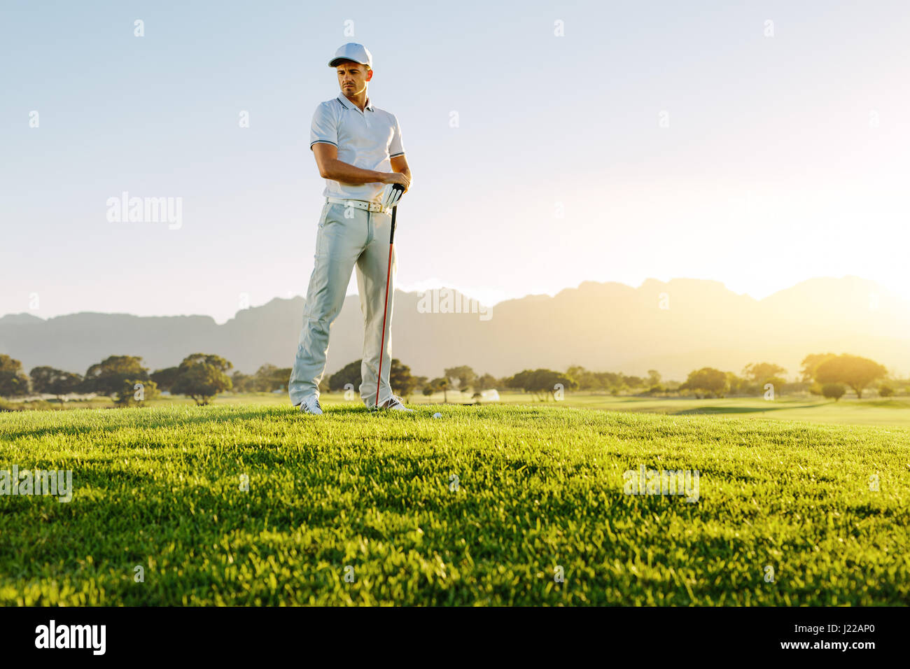 Full length of young man standing on golf course on a summer day. Male