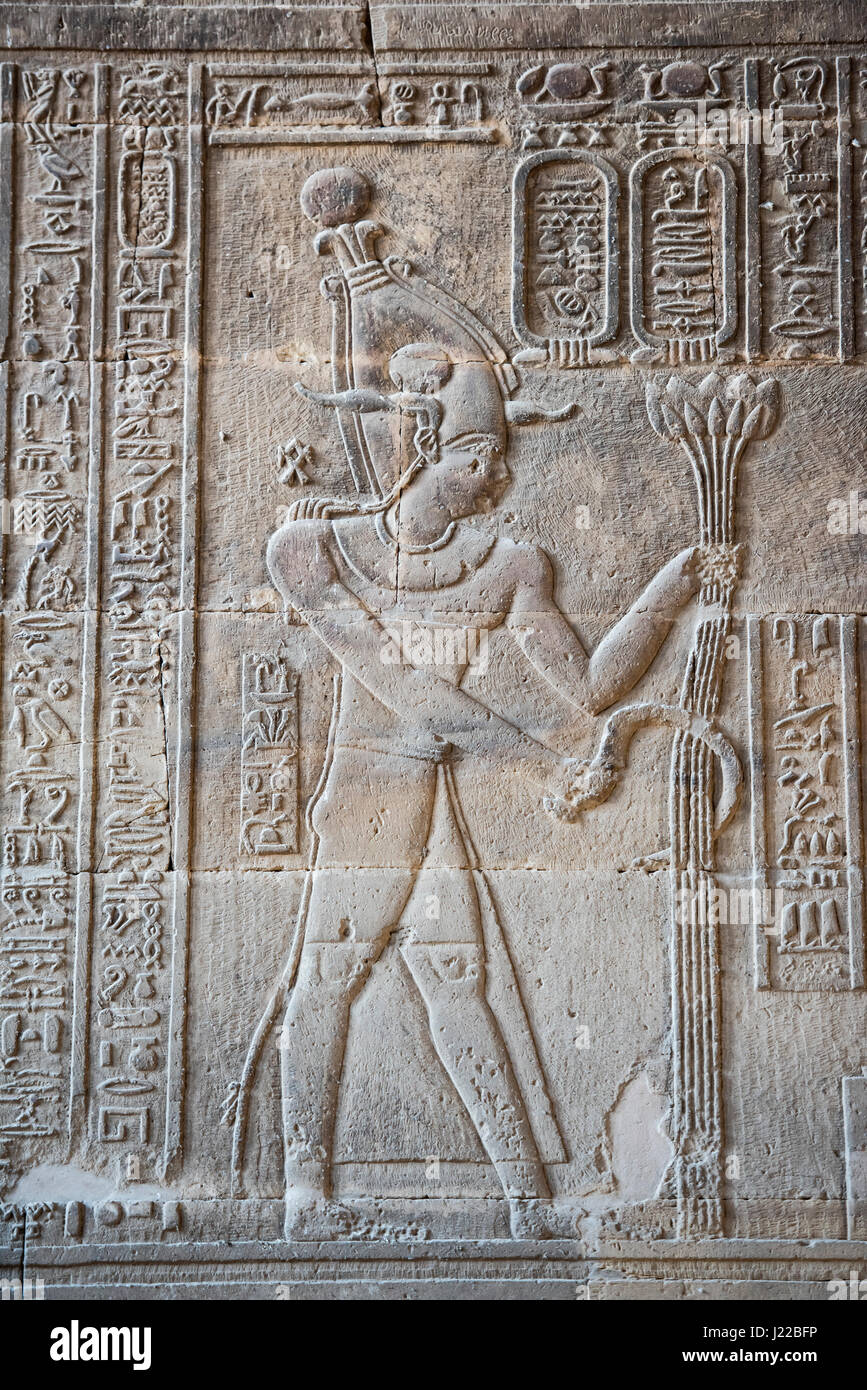 Hieroglypic carvings on wall at the ancient egyptian temple of Khnum in Esna showing god Osiris Stock Photo