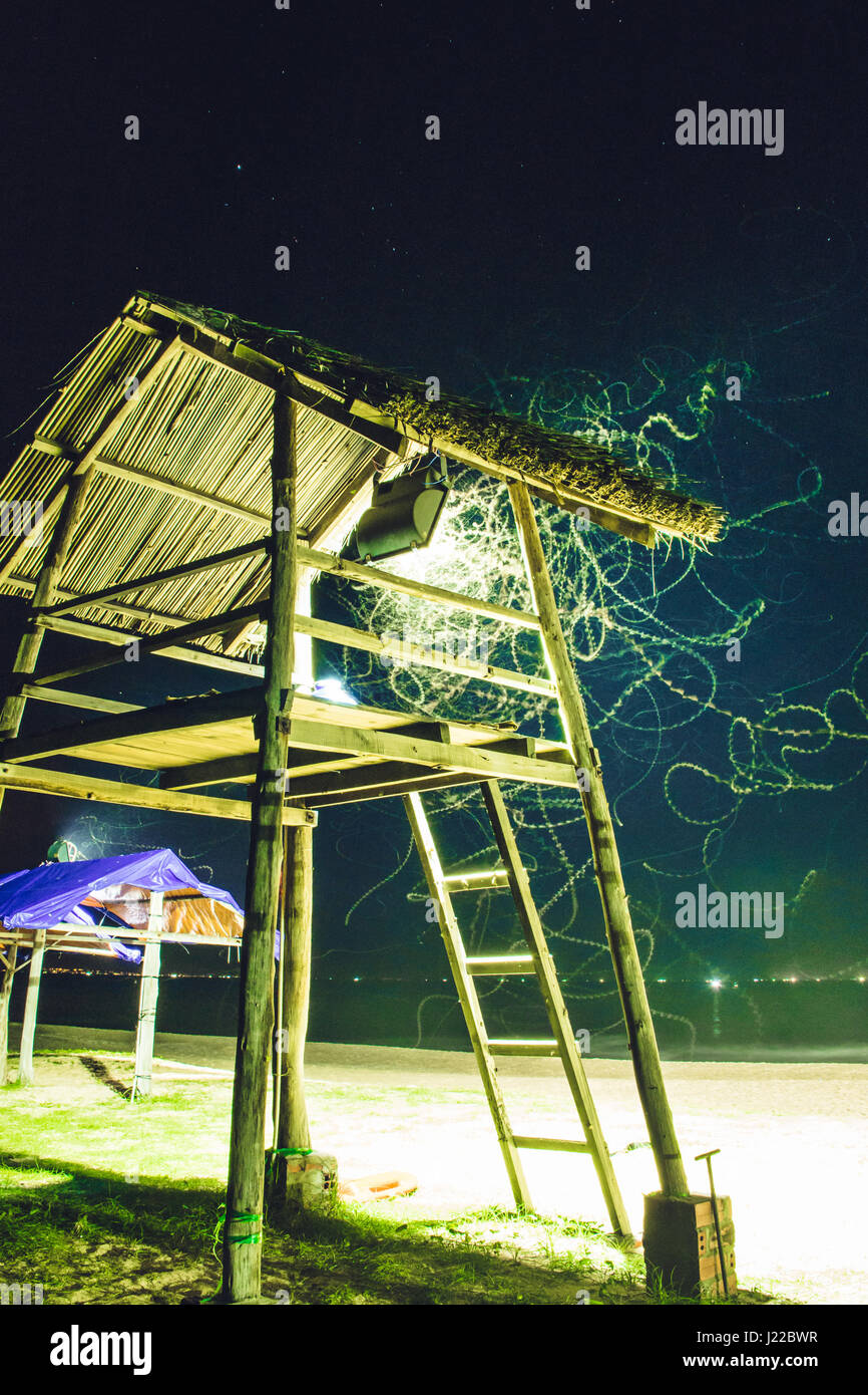 Illuminated bug trails in front of a hut in vietnam Stock Photo