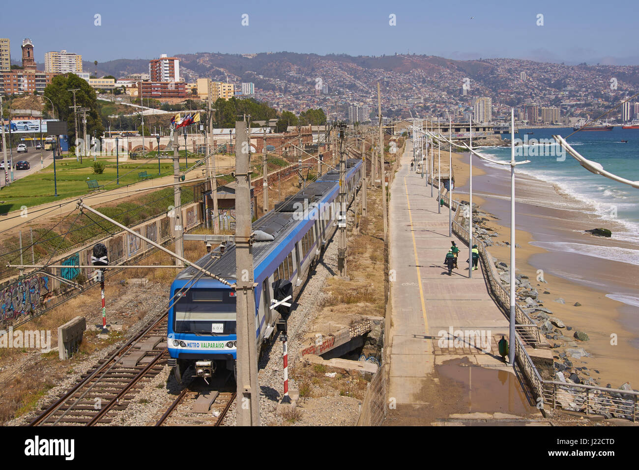 Urban metro train running along the coast in the UNESCO World Heritage port city of Valparaiso in Chile. Stock Photo