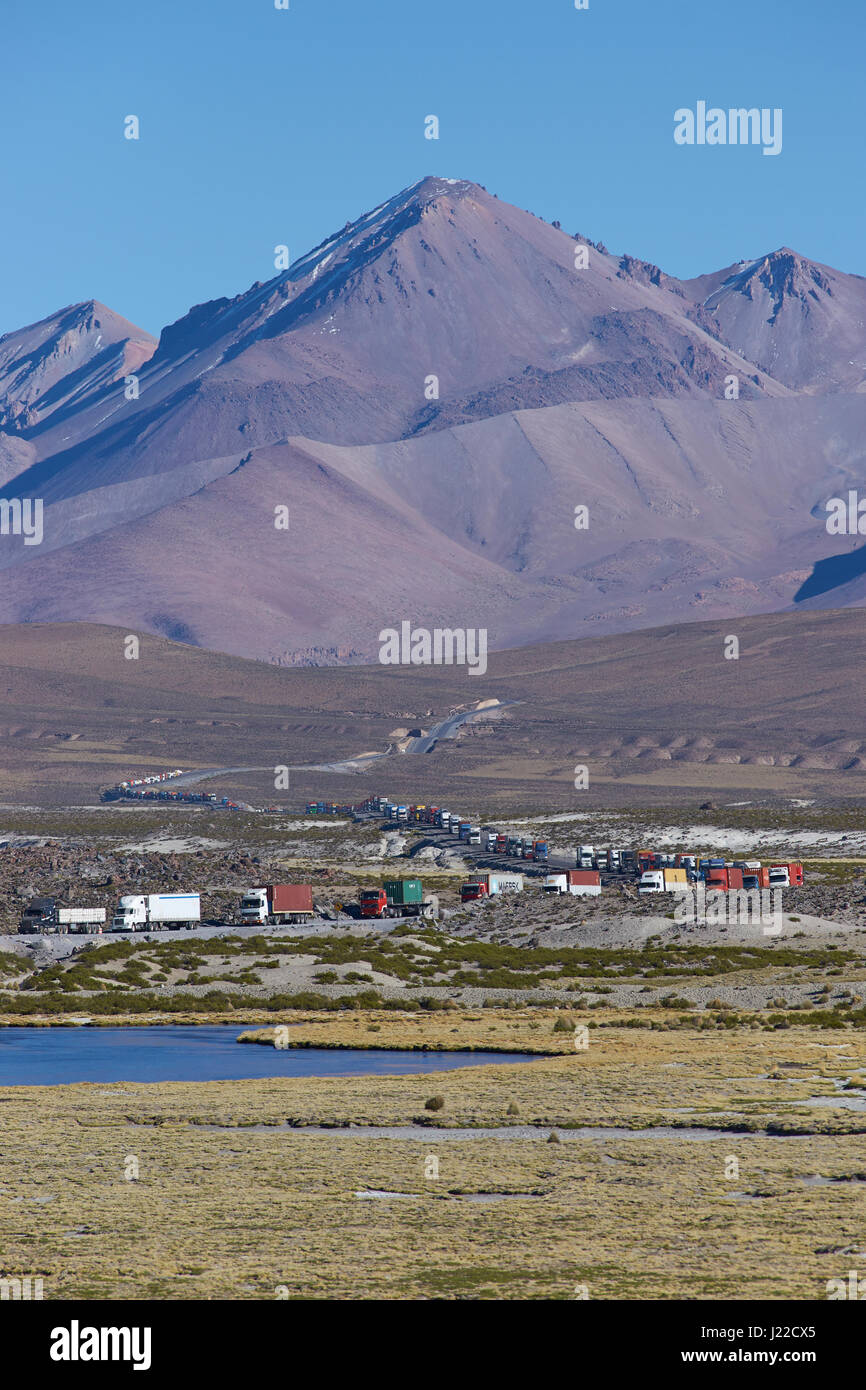 Long line of trucks waiting on the altiplano of northern Chile to cross into Bolivia. Stock Photo