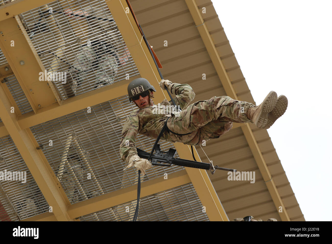 U.S. Army Spc. Dylan Gustaitis, radiology specialist, 215th Brigade Support Battalion, 3rd Armored Brigade Combat Team, 1st Cavalry Division, rappels off a tower at Kuwait’s first Air Assault Course, April 12, 2017, at Camp Buehring, Kuwait. Rappelling off a 50-foot tower is one of several tests students have to pass within in the three phases of the course. The Air Assault Course is a 12-day class that allows U.S. military personnel in the U.S. Army Central area of operations the unique opportunity to become air assault qualified, while deployed outside the continental United States. Stock Photo