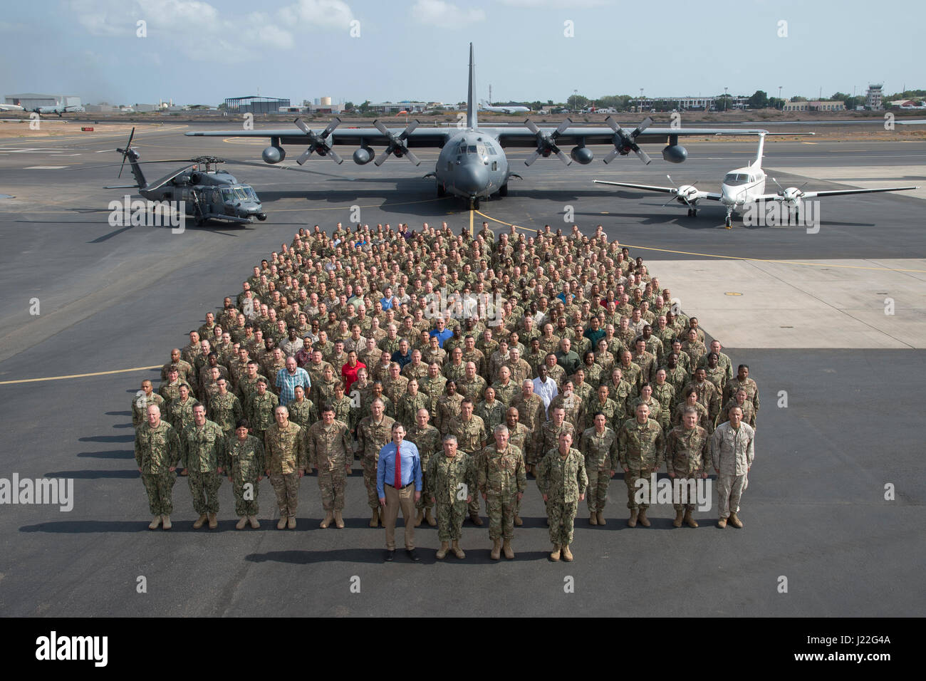 U.S. Soldiers, Sailors, Airmen, Marines, DoD civilians, and contractors representing more than 2,000 members assigned to Combined Joint Task Force-Horn of Africa assemble on the flight line at Camp Lemonnier in Djibouti, April 14, 2017. CJTF-HOA Commanding General Maj. Gen. Kurt Sonntag and Command Senior Enlisted Leader Command Master Chief Geoffrey Steffee, will conclude their tour after a change of command ceremony on April 28. (U.S. Air National Guard photo by Master Sgt. Paul Gorman) Stock Photo