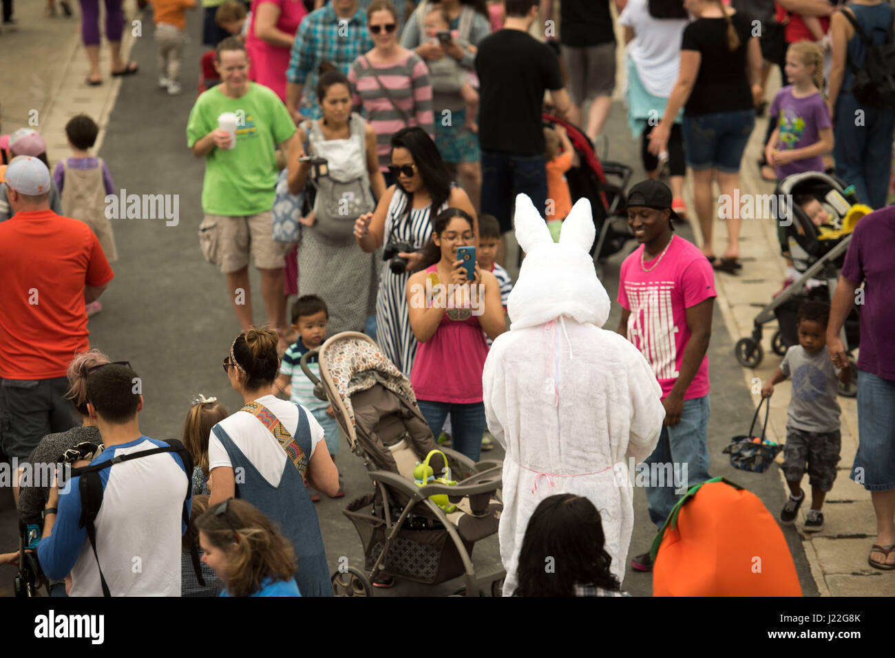 Crowds of families surround an Easter Rabbit for photos during Eggsplosion April 15, 2017, at Kadena Air Base, Japan. Several volunteers dressed up as action heroes, rabbits and carrots during the event. (U.S. Air Force photo by Senior Airman Omari Bernard/Released) Stock Photo