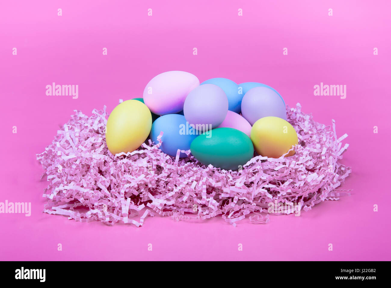 Easter eggs in a nest with pink background Stock Photo - Alamy