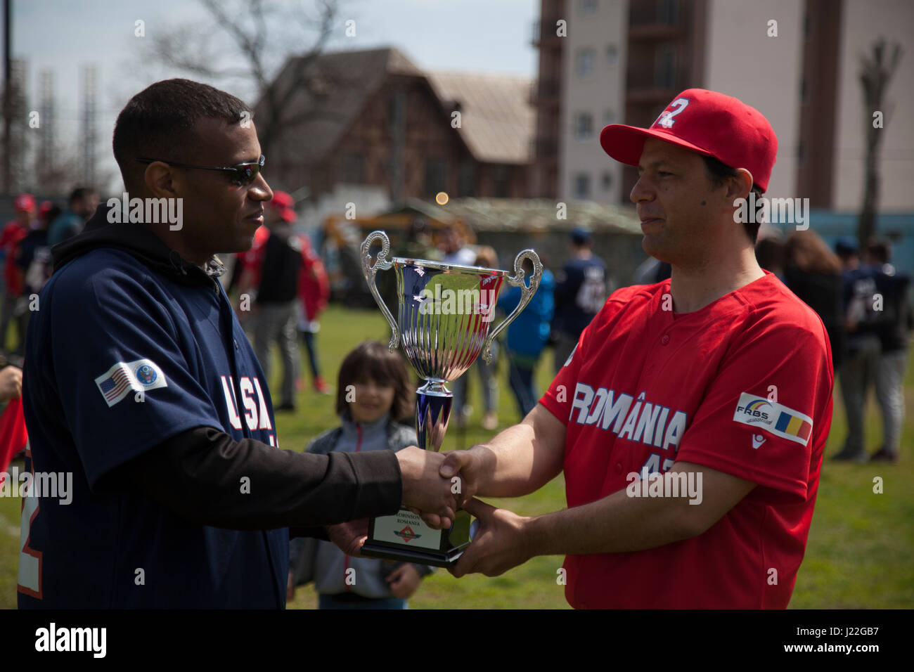 A U.S. Marine with the Black Sea Rotational Force 17.1 congratulates the Romanian coach on winning the Jackie Robinson Day baseball game between the U.S. Marines and a Romanian team in Constanta, Romania, April 15, 2017. The Marine and Romanian players all wore the number 42 jersey in honor of the 70th anniversary of Robinson becoming the first African American player in the Major League Baseball history. (U.S. Marine Corps photo by Cpl. Emily Dorumsgaard) Stock Photo
