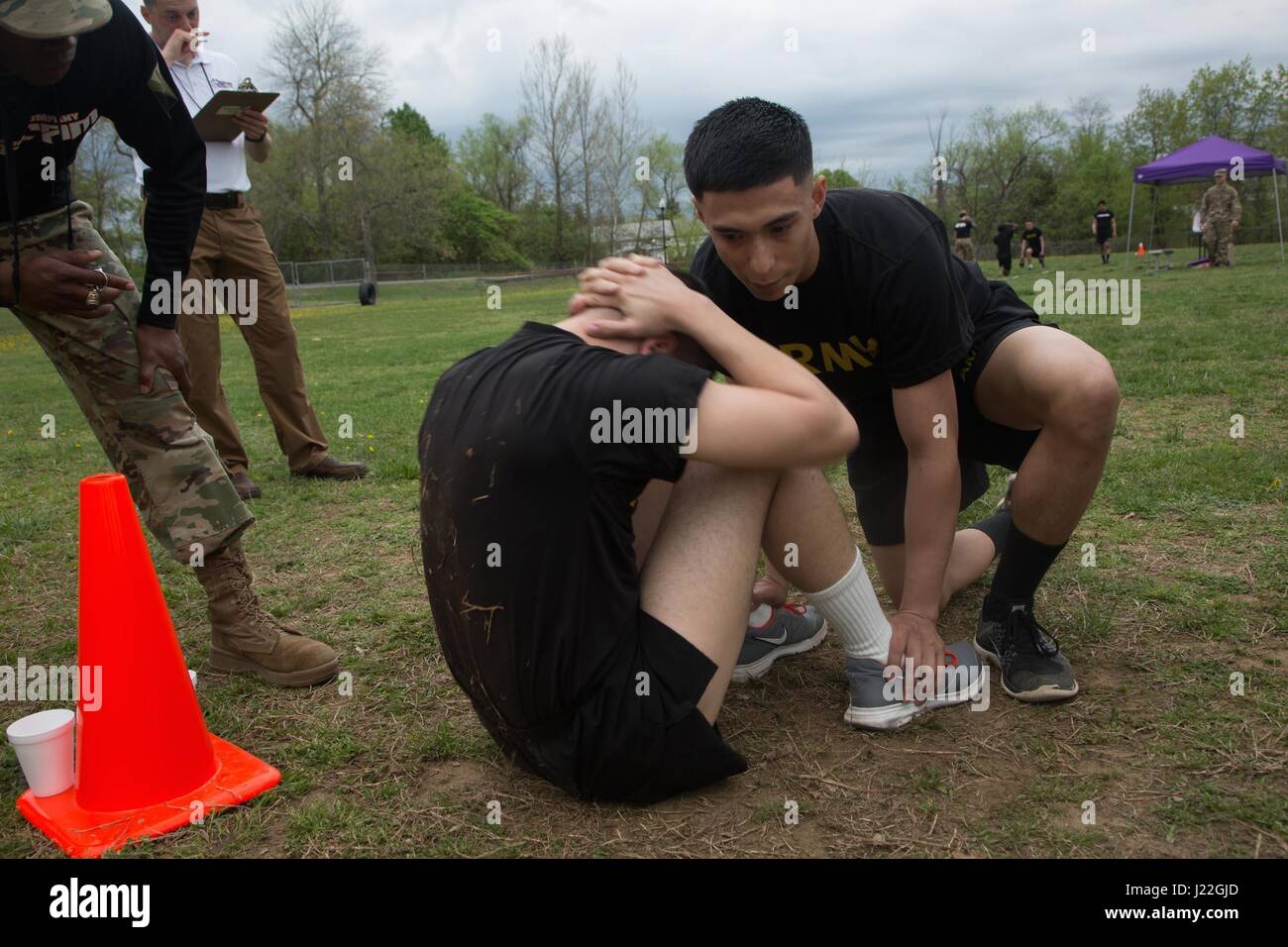 U.S. Army Pfc. Jay Diaz, a Combat Documentation/ Production Specialist, assigned to the 55th Signal Company (Combat Camera), assist his partner in completing the sit-ups event which is part of the Hilda's Challenge that is design to test physical endurance during the 2017 5th Annual SPC Hilda I. Clayton Best Combat Camera (COMCAM) Competition at Fort George G. Meade, Md., April 17, 2017. Diaz is competing in the 2017 5th Annual Best COMCAM Competition where teams of two compete throughout a weeklong event that tests their physical, mental and technical capabilities. The Competition is establis Stock Photo