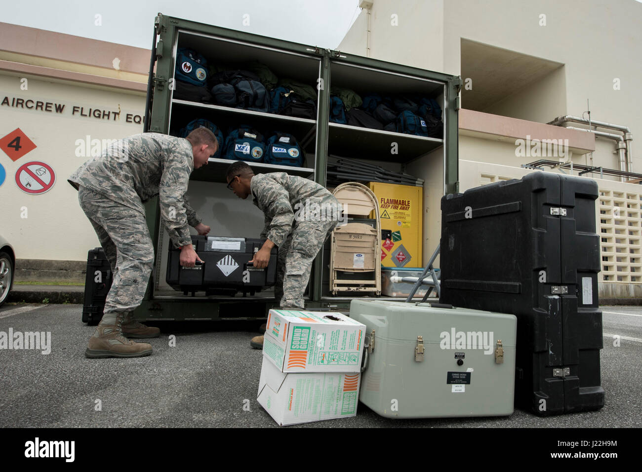 U.S. Air Force Senior Airman Joseph Gago and Airman Nigel Simpson, 18th Operations Support Squadron aircrew flight equipment technicians assigned to the 44th Fighter Squadron, stow away equipment April 18, 2017, at Kadena Air Base, Japan. The AFE team prepares members of the 44th FS to participate in aviation training relocation programs in different parts of the world, such as Guam. (U.S. Air Force photo by Senior Airman John Linzmeier) Stock Photo