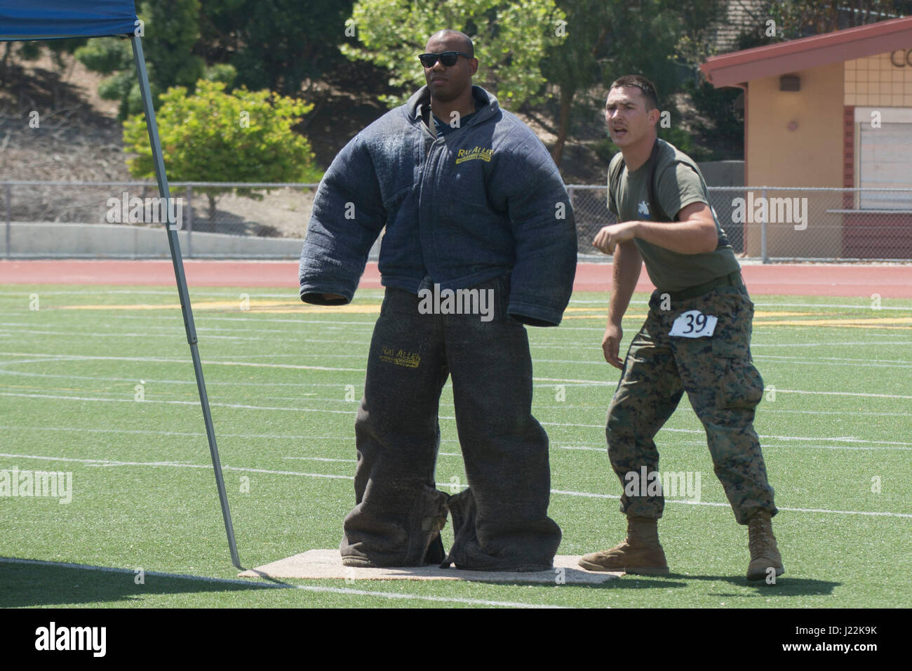 U.S. Marine Corps Lance Cpl. John Ball, right, Provost Marshal Office, calls commands to his canine, Baz, as he navigates through an obstacle for the 1st Annual City of Oceanside Public Safety Fair at El Camino High School football field in Oceanside, Calif., April 22, 2017. (U.S. Marine Corps photo by Lance Cpl. Brooke Woods) Stock Photo