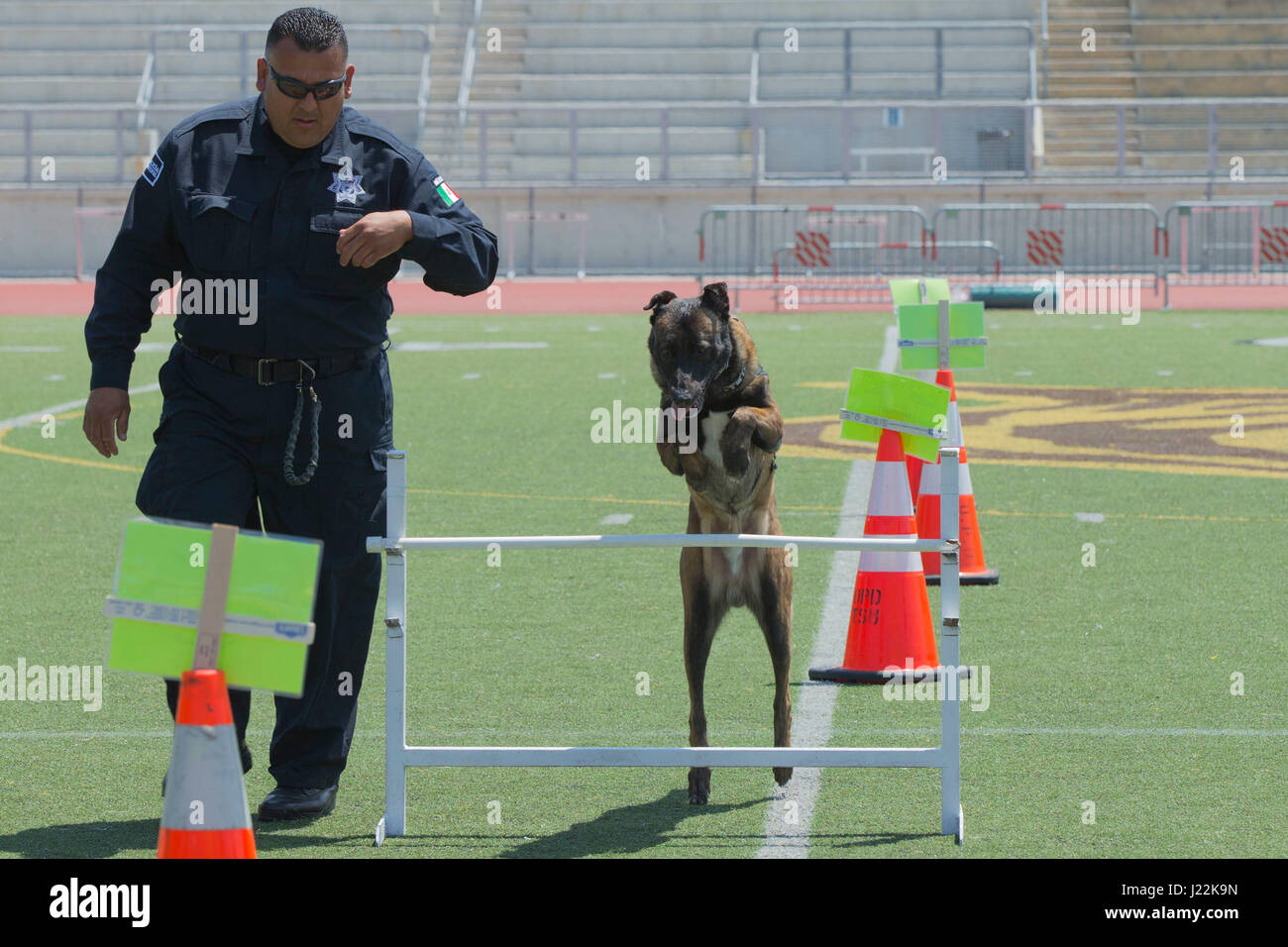 Police Chief Basilio Quiroga, Department of Mexico Police Canine Unit, runs his canine, Definin, through an obstacle for the 1st Annual City of Oceanside Public Safety Fair at El Camino High School football field in Oceanside, Calif., April 22, 2017. (U.S. Marine Corps photo by Lance Cpl. Brooke Woods) Stock Photo