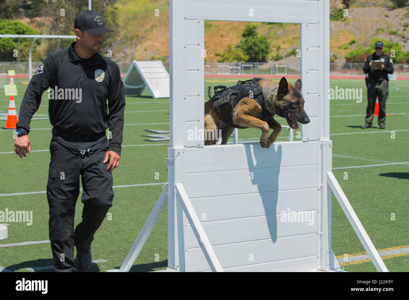 Police Officer Fryan Rodriguez, West Covina Police Department, runs his canine, Reiko, through an obstacle for the 1st Annual City of Oceanside Public Safety Fair at El Camino High School football field in Oceanside, Calif., April 22, 2017. (U.S. Marine Corps photo by Lance Cpl. Brooke Woods) Stock Photo