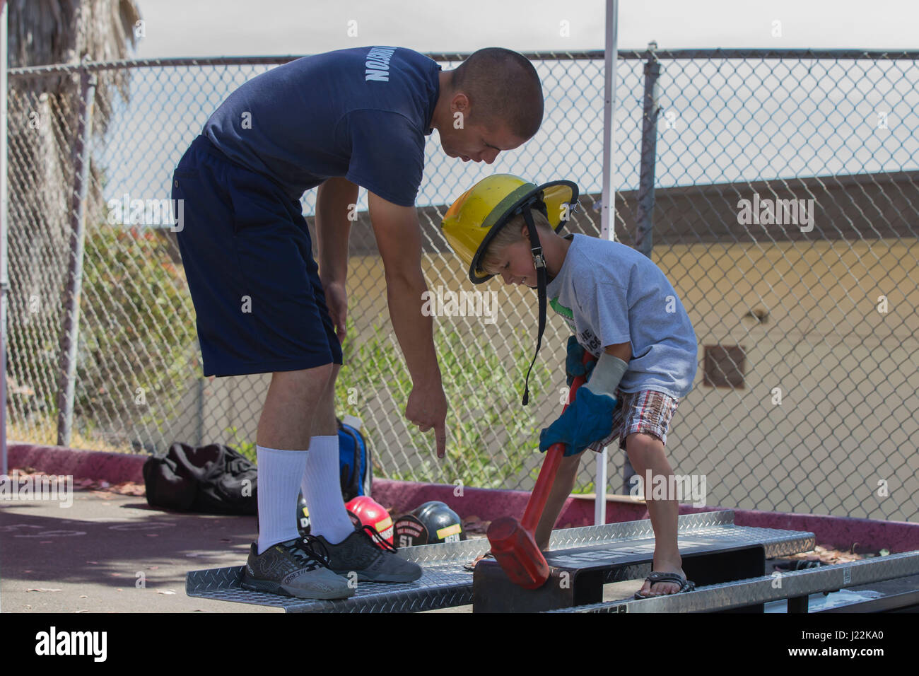 Recruits with the 51st Fire Academy, show children how to use a Keiser Sled, which simulates forcible entry into a building at the 1st Annual City of Oceanside Public Safety Fair at El Camino High School football field in Oceanside, Calif., April 22, 2017. (U.S. Marine Corps photo by Lance Cpl. Brooke Woods) Stock Photo