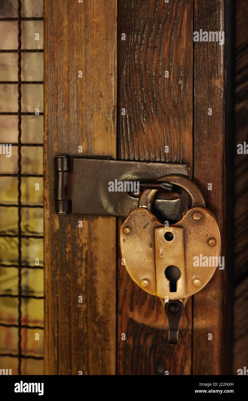 Old padlock on a wooden door with grid Stock Photo