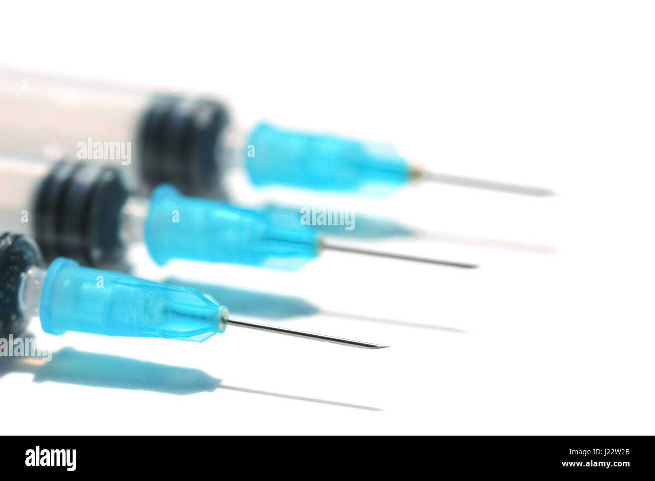 hypodermic needles and syringes on white with shallow d.o.f Stock Photo