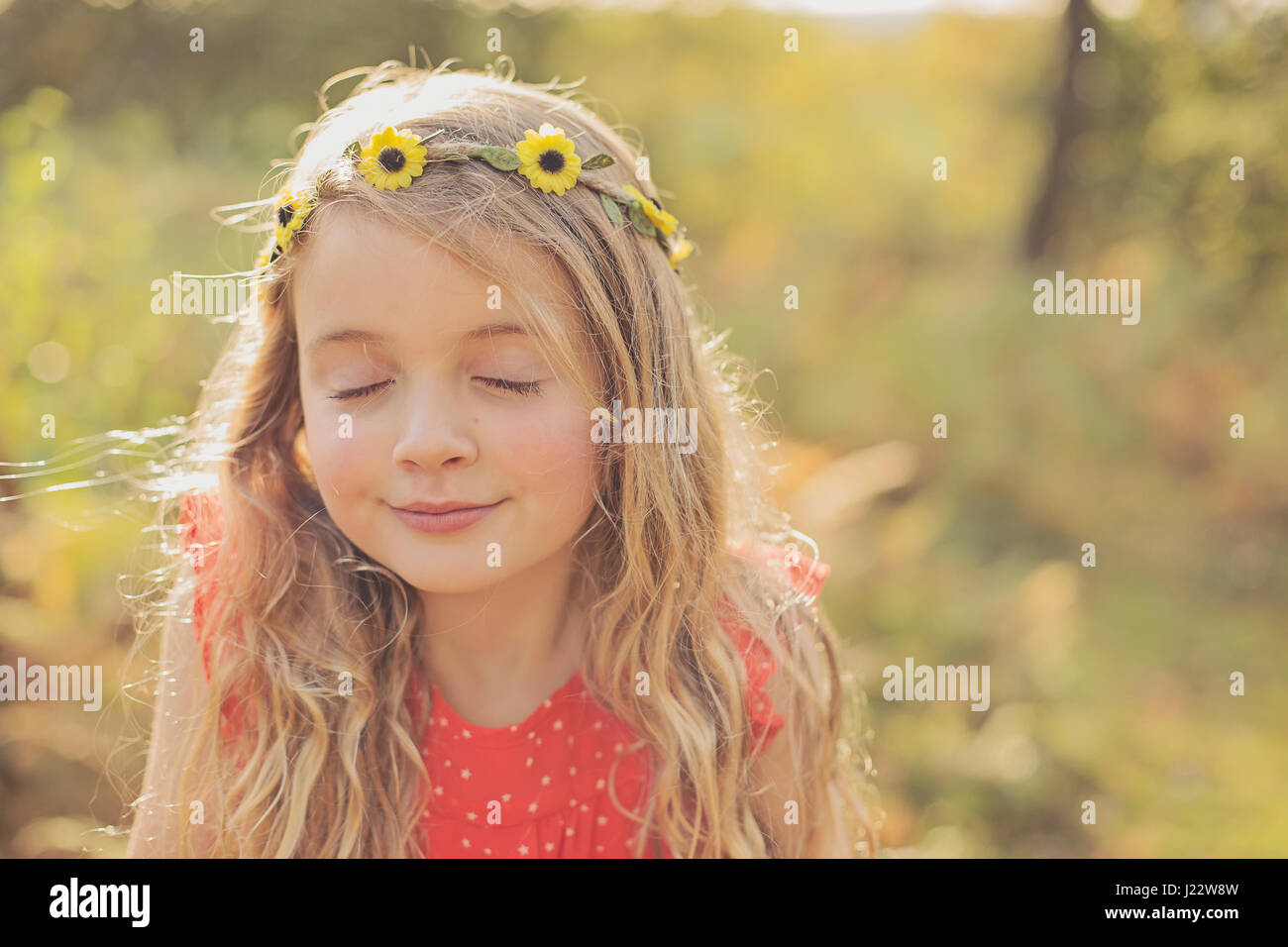 Portrait of relaxed little girl with eyes closed wearing flower wreath Stock Photo