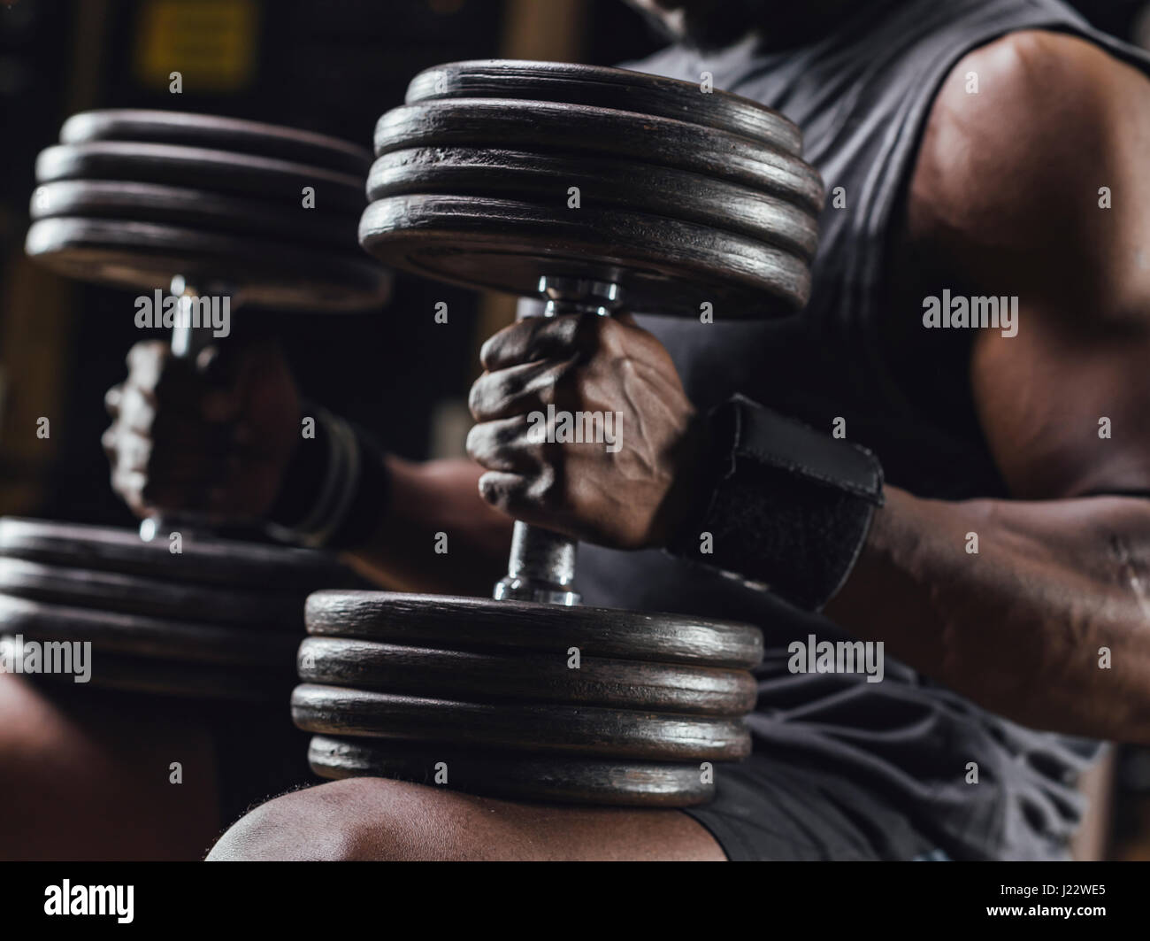Athlete traing with dumbbells in gym, close up Stock Photo