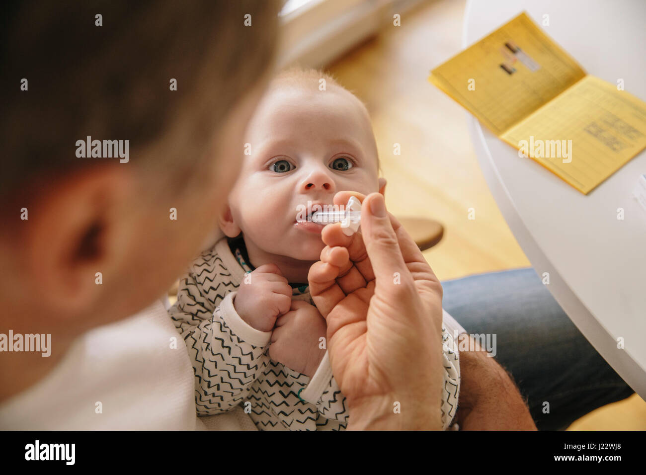 Three-month-old baby receiving oral vaccination Stock Photo