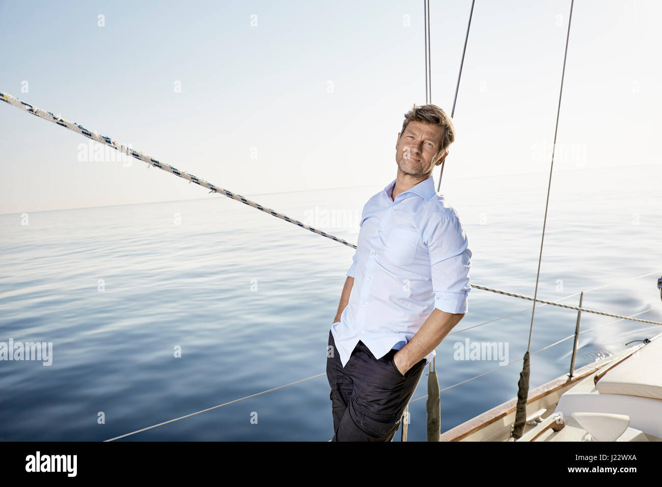 Portrait of smiling mature man standing on his sailing boat Stock Photo ...