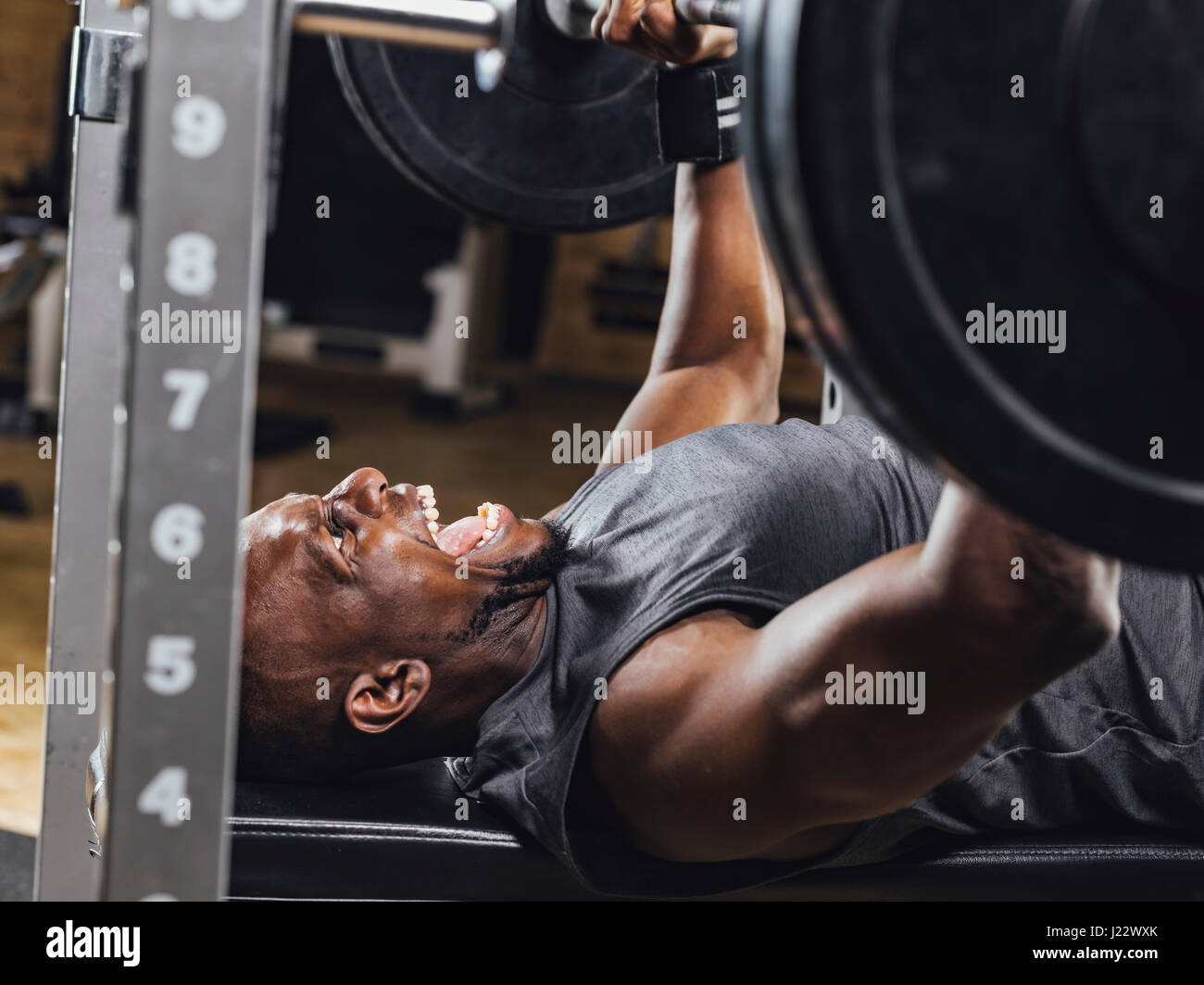 Athlete in gym doing weight lifting Stock Photo