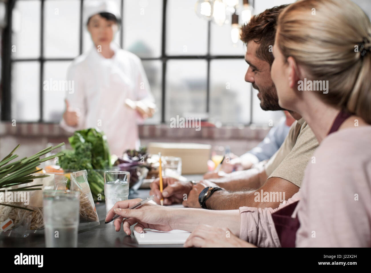 People writing down notes in cooking class Stock Photo